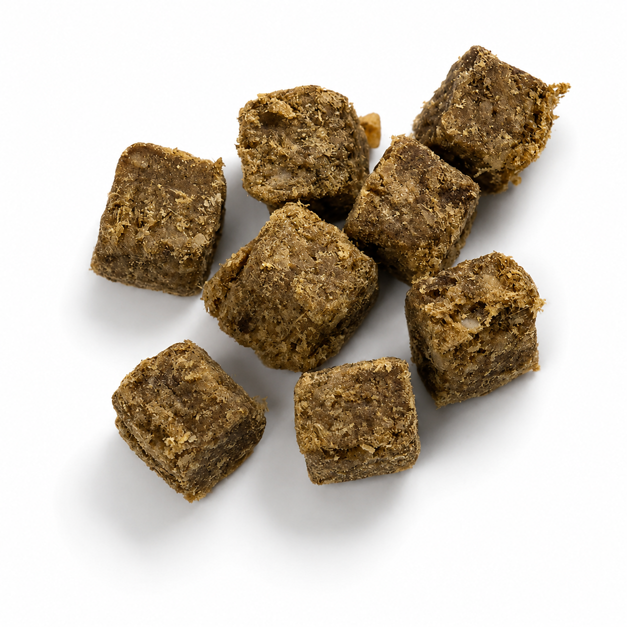 Acht kleine, braune Fleischwürfel mit grober Struktur liegen locker auf einem weißen Hintergrund. Die getrockneten Hundesnacks werden durch weiche, natürliche Schatten hervorgehoben.