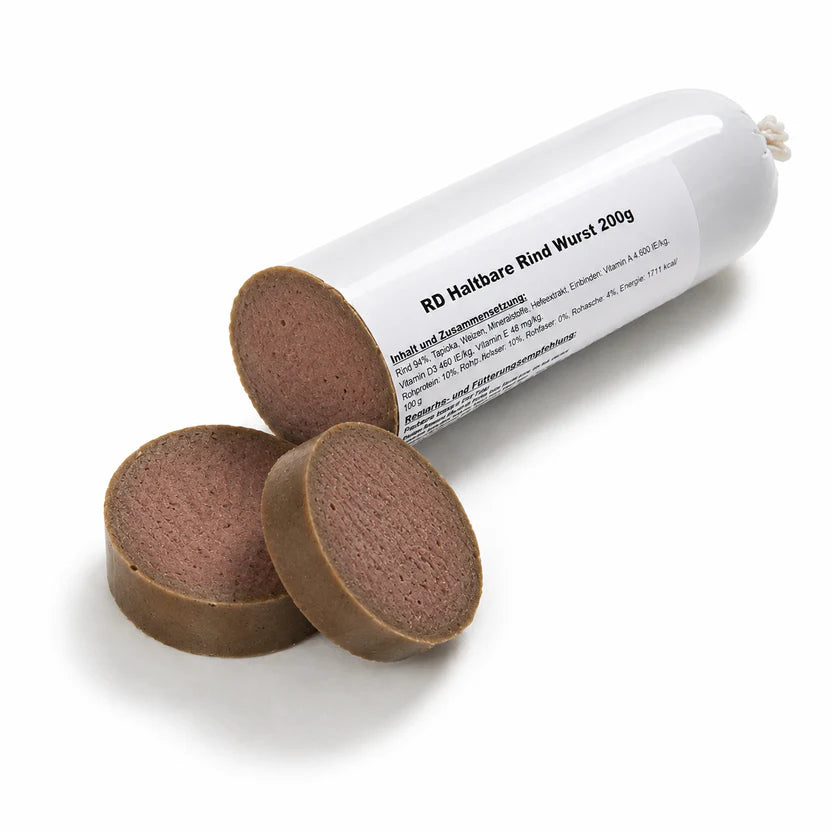 Eine angeschnittene haltbare Rindwurst für Hunde (200 g) liegt auf einem weißen Hintergrund. Das abgeschnittene Endstück ist neben der geöffneten Wurst platziert und zeigt die glatte, schnittfeste Struktur. Ein weicher, natürlicher Schatten sorgt für eine realistische Produktdarstellung.