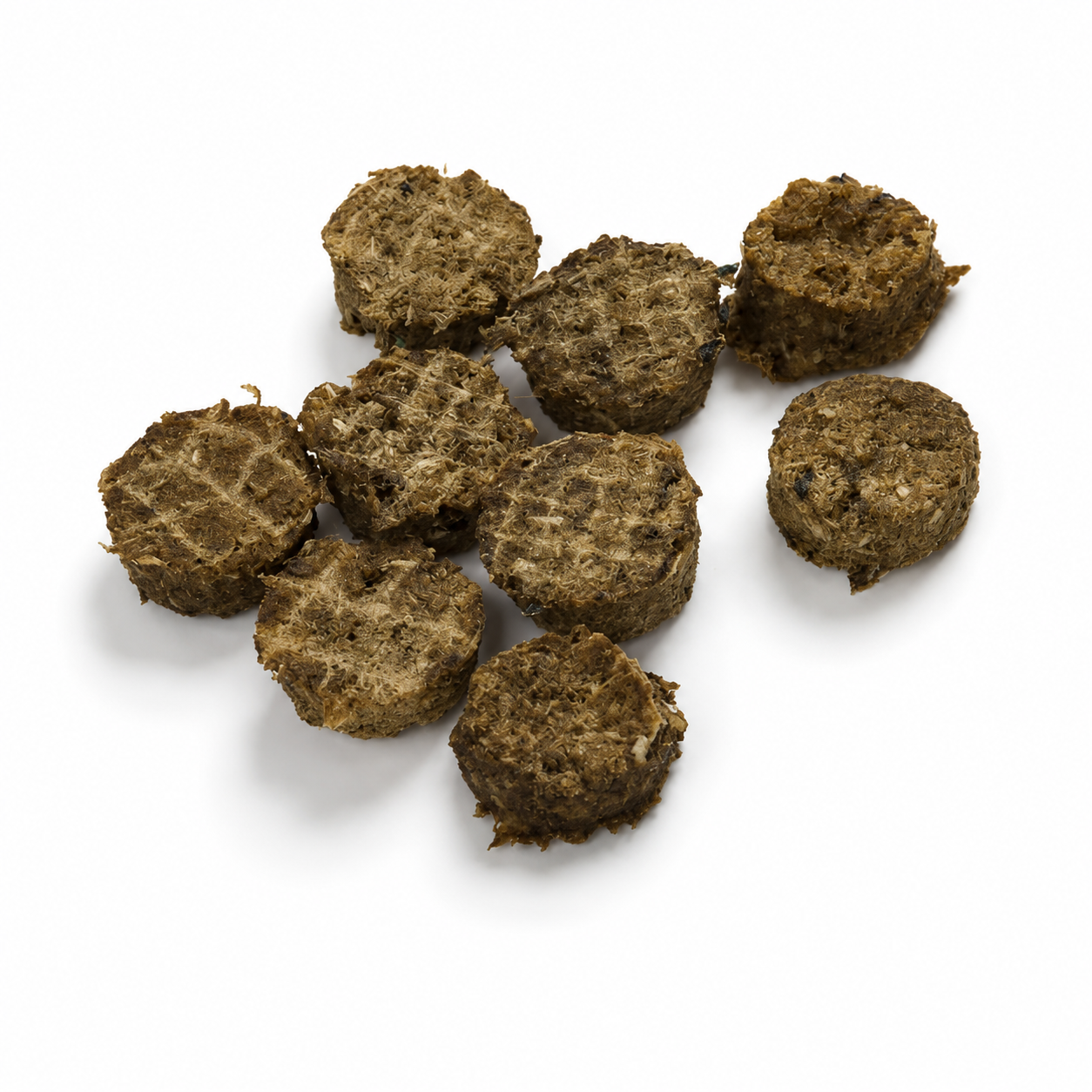 Mehrere runde, getrocknete Lachsfleisch-Taler liegen locker auf einem weißen Hintergrund. Die braunen Hundesnacks mit ihrer faserigen Struktur werden durch weiche, natürliche Schatten hervorgehoben.