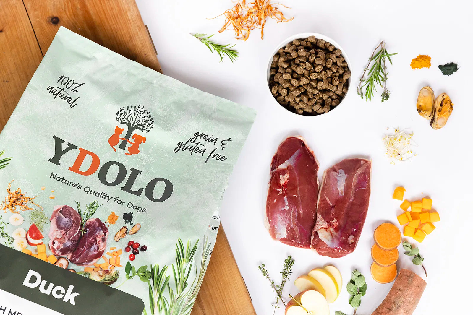YDOLO Ente Semi-Moist Hundefutter im Napf, daneben die grüne Verpackung und die frischen Zutaten. Halbfeuchtes, getreide- und glutenfreies Hundefutter mit 75 % Frischfleisch, Monoprotein und präbiotischen Kräutern – geeignet für Hunde jeder Rasse
