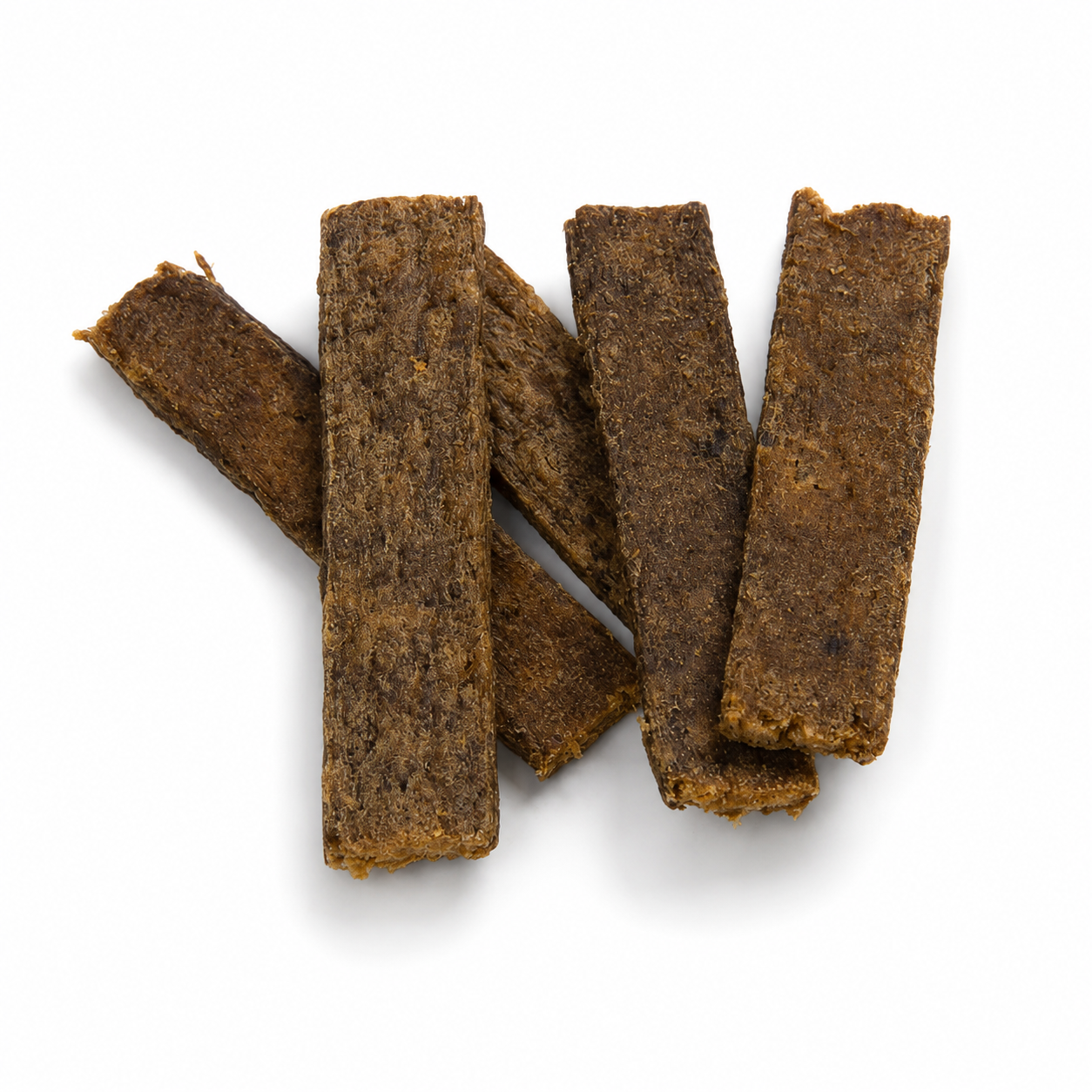 Fünf längliche, braune Ziegenfleischstreifen liegen leicht überlappend auf einem weißen Hintergrund. Die getrockneten Hundesnacks besitzen eine feste, faserige Struktur und werden durch weiche, natürliche Schatten hervorgehoben.